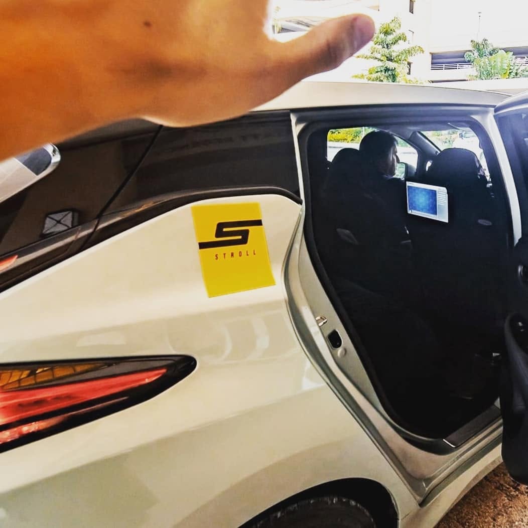 Stroll Guam branded rideshare vehicle with an AdResst headrest display visible in the back seat