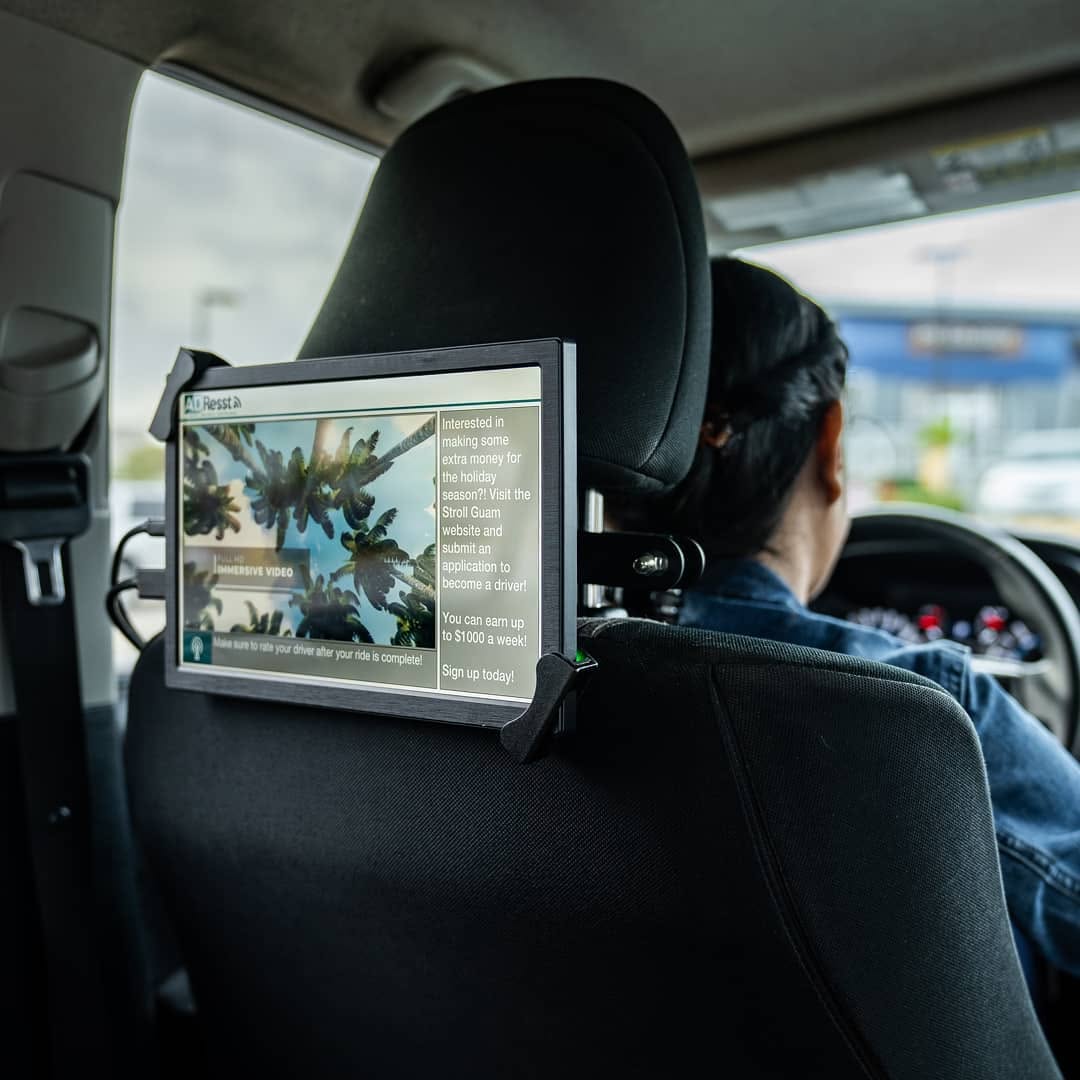 AdResst ultra-HD headrest display running a live campaign inside a Stroll Guam rideshare vehicle